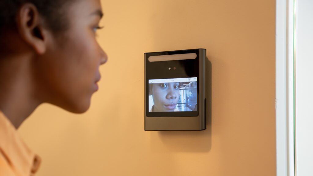 A face scanner being used by a woman to open a doo