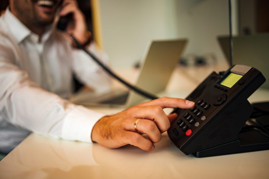 Close up image of a men using phone to order room